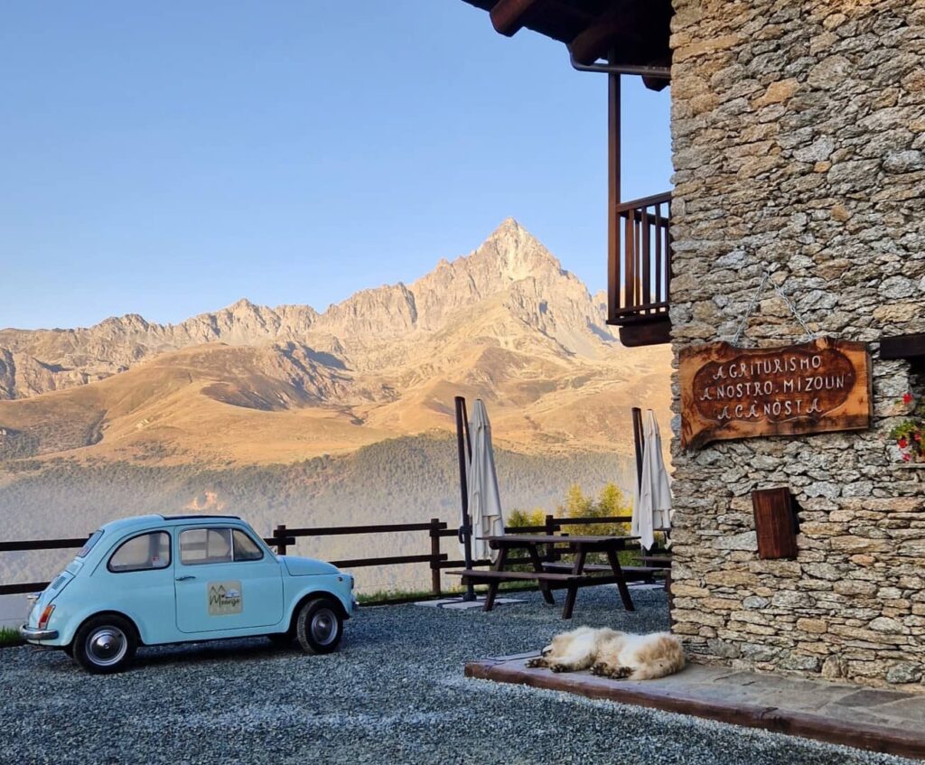 Scenario alpino con una macchina d'epoca in primo piano a Monviso Relax